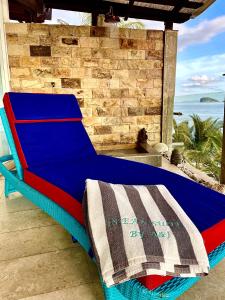 甘地达萨Ocean Suite By A&J - Exceptional Beachfront Apartment - Candidasa的蓝色的床位于门廊上,享有海景