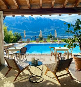 利莫内-苏尔加达Residence Dalco Suites & Apartments的一个带桌椅的庭院和一个游泳池