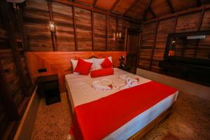 卡尔皮蒂耶Horizon KiteSurfing Beach Resort的一间卧室配有一张带红色枕头的大床