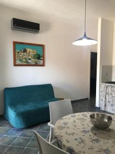 兰佩杜萨Appartamenti L'Approdo del Gabbiano的客厅配有蓝色的沙发和桌子