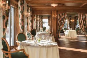 阿罗萨Tschuggen Grand Hotel - The Leading Hotels of the World的用餐室设有桌椅和窗户。