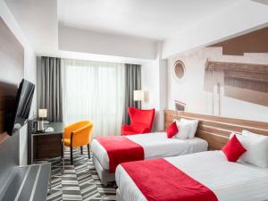 布加勒斯特布加勒斯特乌尼里美居酒店的酒店客房设有两张床和电视。