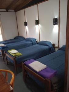 UsnoTierra Yacampis264的一间设有三张蓝色的床和一张桌子的房间