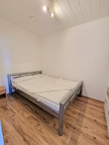 海利根港Ferienpark O02-004的铺有木地板的白色客房的一张床位