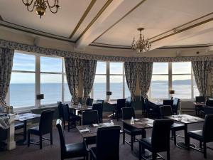 斯卡伯勒大不列颠斯卡伯勒豪华酒店的用餐室设有桌椅和窗户。