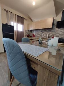 特里波利斯Aithra 2的厨房配有带蓝色椅子的大木桌