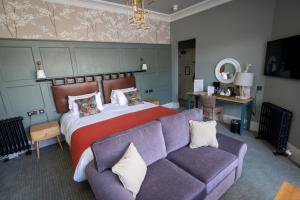 梅奈布里奇Victoria Hotel by Chef & Brewer Collection的一间卧室配有一张床和一张沙发
