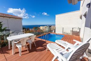 罗萨斯RNET - Casa 4 - Vista Mar Almadrava Roses的一个带桌椅的甲板和一个游泳池