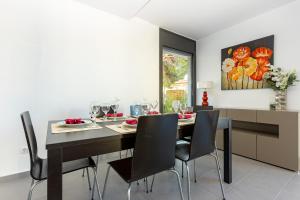 罗萨斯RNET - Casa 4 - Vista Mar Almadrava Roses的一间用餐室,配有黑色的桌子和椅子