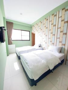 台南108巷会馆的一间卧室设有两张床和窗户。