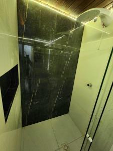 萨尔瓦多Apartamento único na praia do Farol de Itapuã的一间设有黑色墙壁淋浴的浴室
