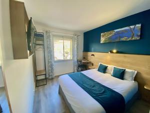 滨海福斯The Originals City, Hôtel Azur, Fos-sur-Mer的一间卧室设有一张蓝色墙壁的大床