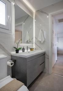 瓦里Sea view penthouse in Vari的白色的浴室设有水槽和镜子