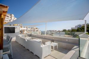阿尔布费拉Sun Lovers Hostel的阳台配有白色家具,享有城市美景。