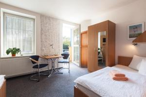 维什科夫天狼星膳食公寓的酒店客房带一张床、一张桌子和椅子