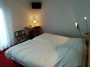 阿戈斯维达洛斯切斯皮埃阿格斯酒店的一间卧室配有一张床和一张带台灯的书桌