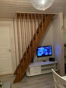 ÅmotsforsStuga i Valfjället的客房设有带电视和书桌的楼梯。