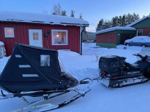 斯韦格Mitt i Sveg, Färjegatan 6的停在红房子前面的雪地车