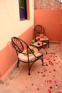 马拉喀什Riad Bab Nour的地板上配有两把椅子和一张带鲜花的桌子