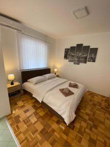 索科矿泉村Apartmani Milojić的卧室设有一张白色大床和木地板