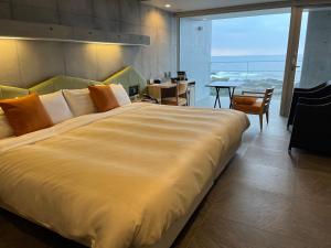 屋久岛THE HOTEL YAKUSHIMA ocean & forest的一张大床,位于带大窗户的房间里