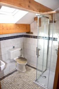 The Coach House的一间带卫生间和玻璃淋浴间的浴室