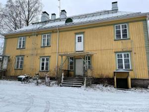 许温凯Yksiö+autopaikka/Small apt.+free parking的前面有雪的黄色房子