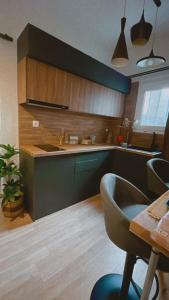 比雷埃夫斯Marina Zeas Seaside Studio-MarinaQ的厨房配有绿色橱柜和桌椅