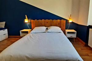 米卢斯La cachette - Maison centre的一间卧室配有一张带2个床头柜的大床