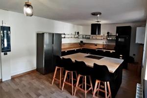 米卢斯La cachette - Maison centre的厨房配有木桌和黑色椅子