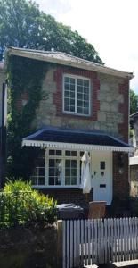 文特诺Quince Cottage的一座砖房,上面有蓝色遮阳篷