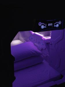 嘉义市享绽二三星球旅馆的黑暗客房内的紫色灯光床