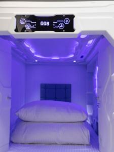 嘉义市享绽二三星球旅馆的紫色卧室,配有一张上面标有标志的床