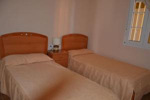 韦尔瓦Luxury Apartment in Marina de Isla Canela- Beach Front的两张睡床彼此相邻,位于一个房间里