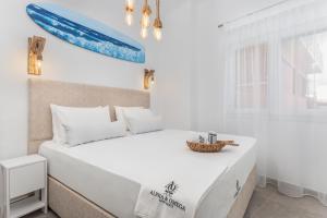 卡尔帕索斯Alpha & Omega的卧室配有一张大白色床和窗户