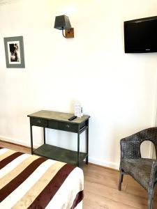 圣马迪拉莫卢马克斯酒店的一间卧室配有桌子、椅子和电视