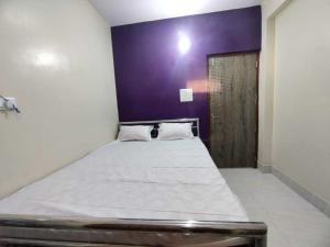 SonpurOYO The Pine & Dine的一间卧室配有一张大床和紫色墙壁