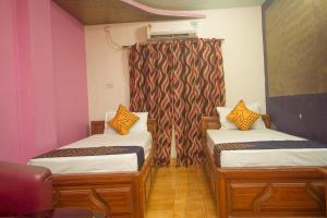 Alīpur DuārOYO Hotel Chitra的带两张床和窗帘的房间
