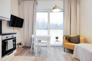 埃斯波Forenom Serviced Apartments Espoo Saunalahti的一个带桌子和椅子的小客厅