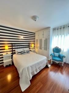 阿尔科巴萨Cocas House - Alcobaça的一间卧室配有一张床和一张蓝色椅子
