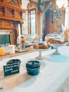 滨海阿热莱斯B&B Château Valmy - Teritoria的餐桌,带食物盘和一瓶葡萄酒