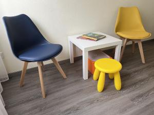 塞埃巴克Ferienwohnung Wilde7的两张椅子和一张带黄凳的桌子