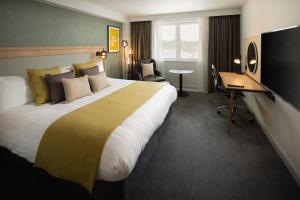 牛津假日牛津酒店的酒店客房设有一张大床和一张书桌。