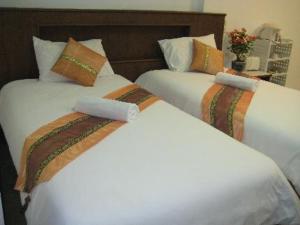 拉迈拉迈完美度假酒店的两张白色的床,彼此相邻,位于一个房间里
