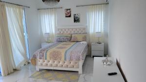 佩德纳莱斯Madome Aparta Hotel的一间白色卧室,配有床和2个窗户