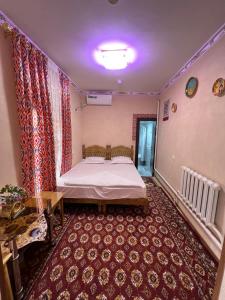 布哈拉''NAVO'' Guest House的卧室配有一张床