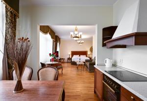 玛丽亚温泉罗马撒酒店的厨房以及带桌椅的起居室。