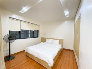 河内NINE HOUSING 92 Dao Tan的卧室配有白色的床和窗户。