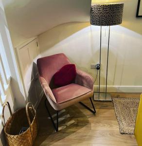 墨尔本Luxury 2 bed cottage in the centre of Melbourne的红色枕头的粉红色椅子