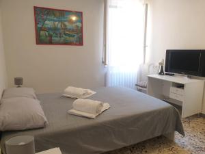 奥西莫SENZATESTA 2的一间卧室配有一张床和一张书桌及电视